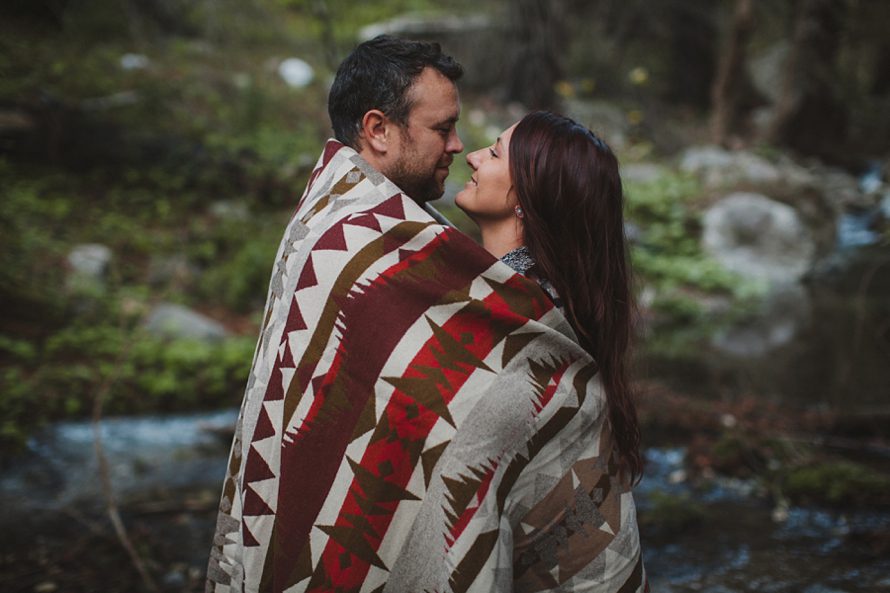 Couple wrapped in pendleton blanket in engagement photos