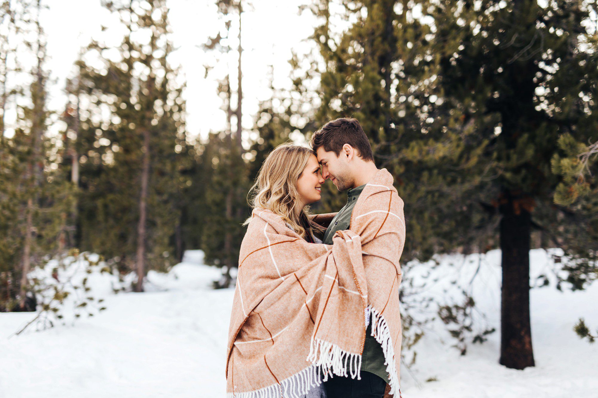 Couple snuggled up in snow in Bend Oregon