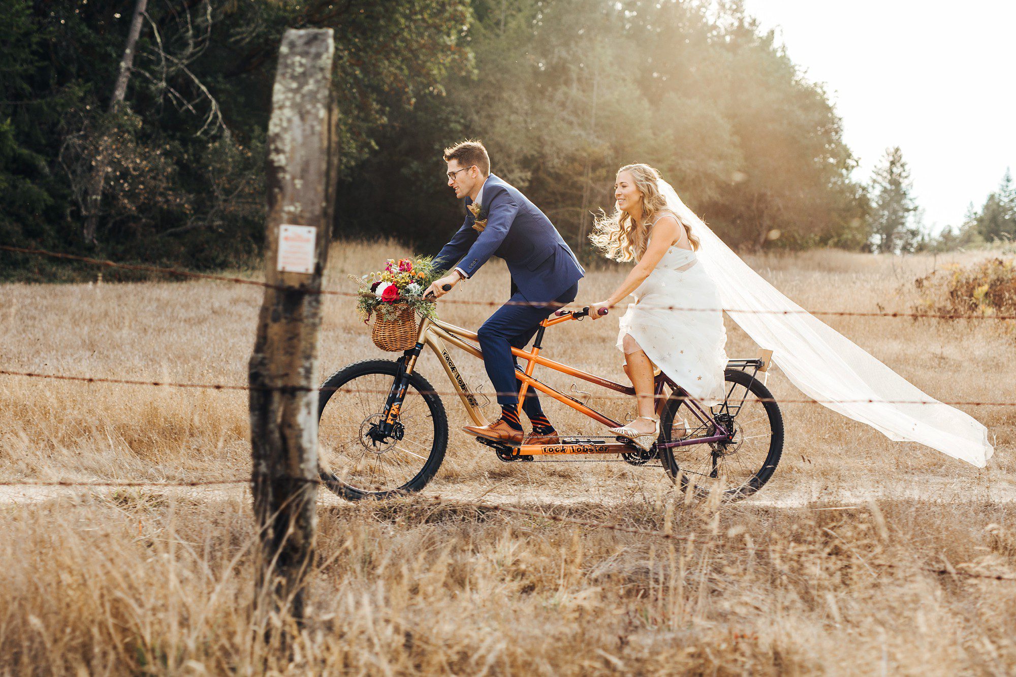 Bride and groom riding tandem bike